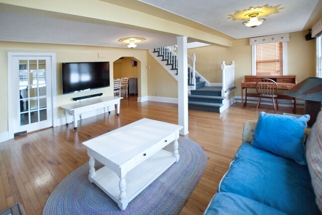 260 Oak Island Dr, Wolverine Lake, MI 48390 - living room featuring arched walkways, stairway, baseboards, and wood finished floors