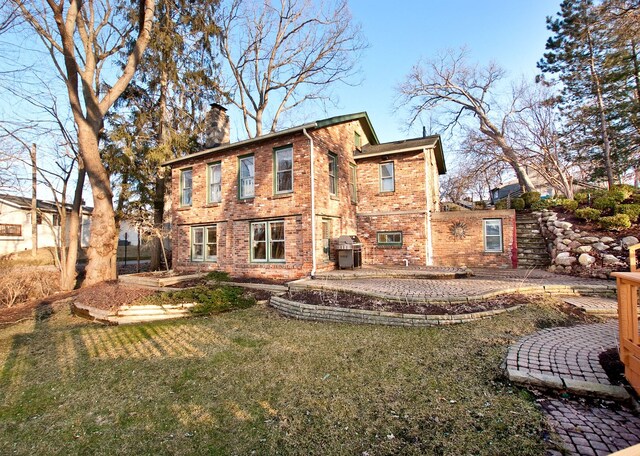 260 Oak Island Dr, Wolverine Lake, MI 48390 - back of property featuring a chimney, brick siding, a patio, and a yard