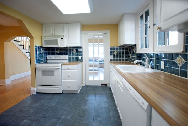 kitchen with white cabinets, decorative backsplash, white appliances, and sink