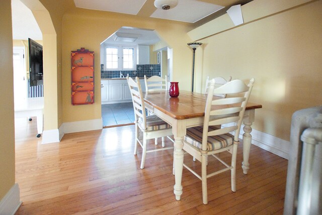 260 Oak Island Dr, Wolverine Lake, MI 48390 - dining area with arched walkways, light wood finished floors, and baseboards