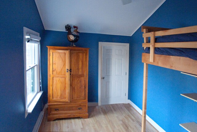 260 Oak Island Dr, Wolverine Lake, MI 48390 - unfurnished bedroom featuring lofted ceiling, light wood-type flooring, baseboards, and multiple windows