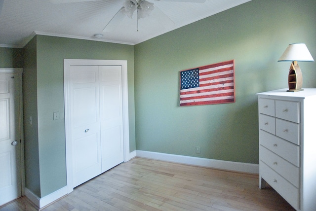 unfurnished bedroom with a closet, light hardwood / wood-style floors, ceiling fan, and crown molding