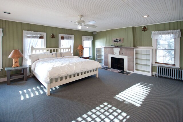 260 Oak Island Dr, Wolverine Lake, MI 48390 - carpeted bedroom with radiator, a fireplace with raised hearth, and a ceiling fan