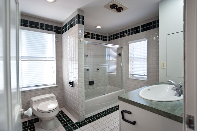 full bathroom with tile patterned floors, vanity, tile walls, and toilet