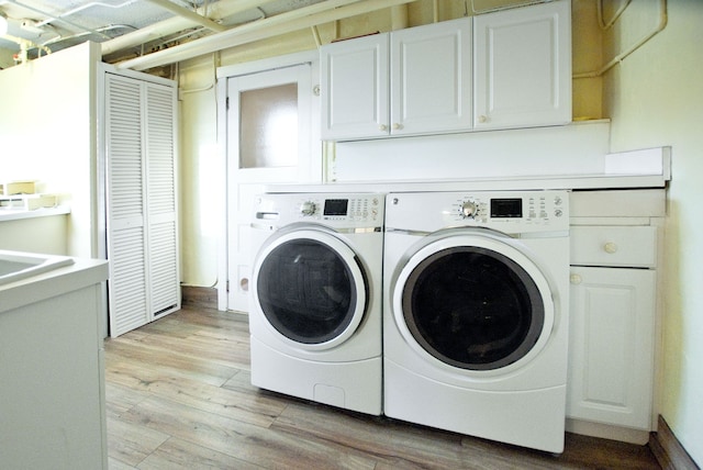 laundry area featuring light hardwood / wood-style floors, cabinets, and independent washer and dryer