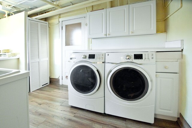 260 Oak Island Dr, Wolverine Lake, MI 48390 - washroom featuring cabinet space, washing machine and dryer, and light wood-type flooring