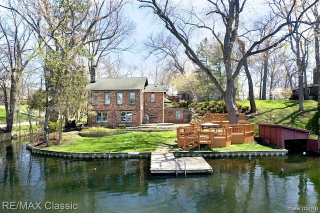 view of dock featuring a lawn and a deck with water view