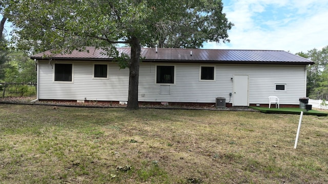 back of house with central AC and a yard