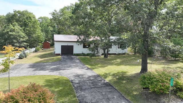 view of front of house with an outbuilding, a garage, and a front lawn