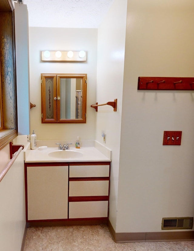 bathroom with vanity and a textured ceiling