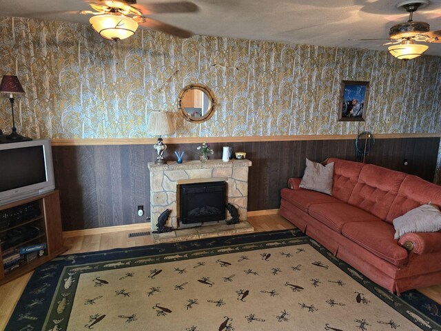 1127 Tolley Park Dr, Union City, MI 49094 - living room featuring ceiling fan, wallpapered walls, a wainscoted wall, and a fireplace