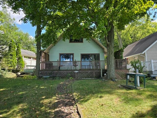 back of property featuring a lawn and a deck