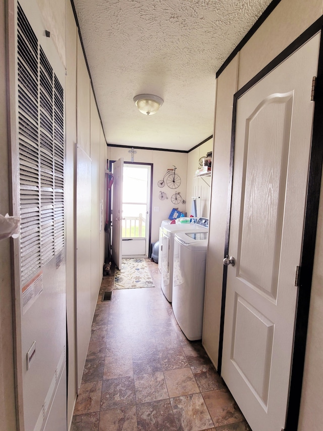 laundry room with crown molding, washing machine and clothes dryer, and a textured ceiling