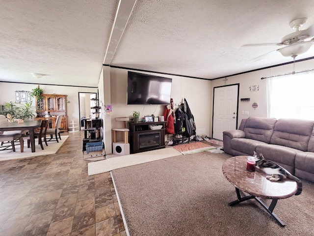 living room with ceiling fan, crown molding, and a textured ceiling