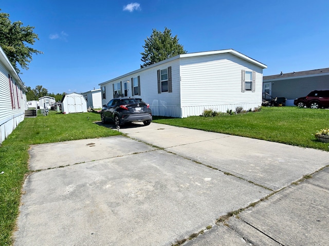 view of side of home with a shed and a lawn