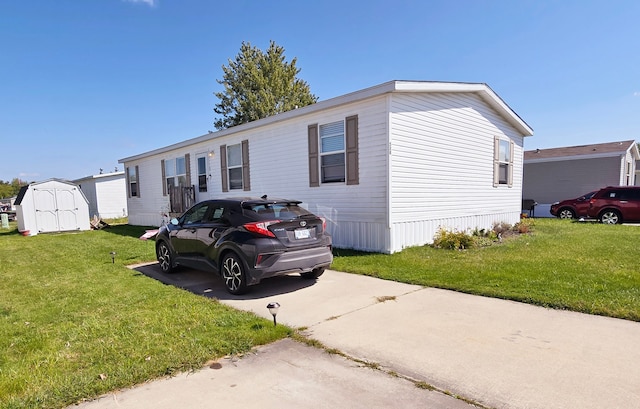 manufactured / mobile home with a storage unit and a front yard