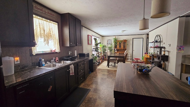 kitchen with a healthy amount of sunlight, sink, a textured ceiling, and decorative light fixtures