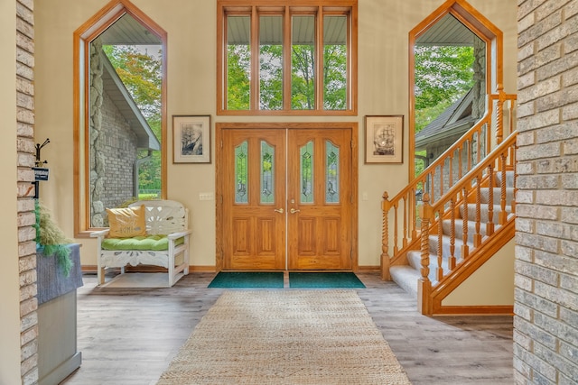 entryway with hardwood / wood-style floors and a high ceiling