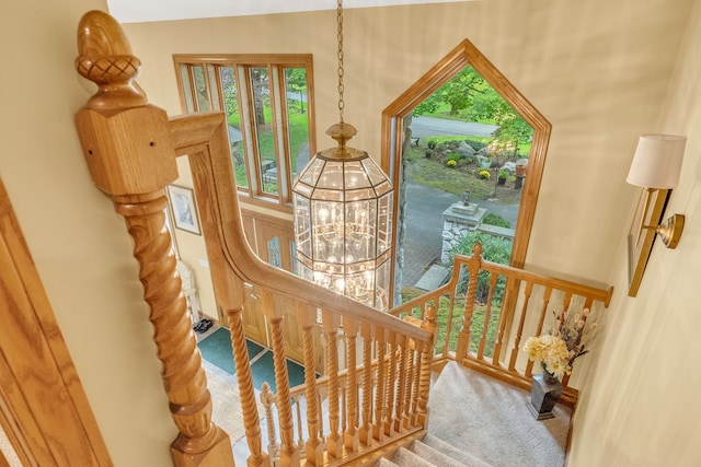 stairs featuring a chandelier