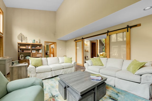 living room with a barn door and light wood-type flooring