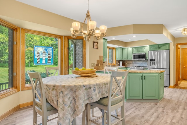 dining room with light wood-type flooring and an inviting chandelier