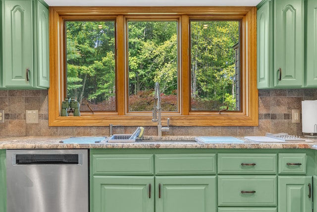 kitchen featuring stainless steel dishwasher, green cabinets, a healthy amount of sunlight, and light stone counters