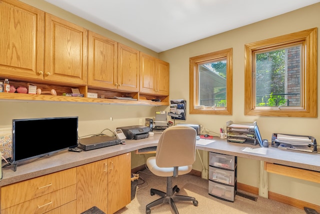 carpeted home office featuring built in desk