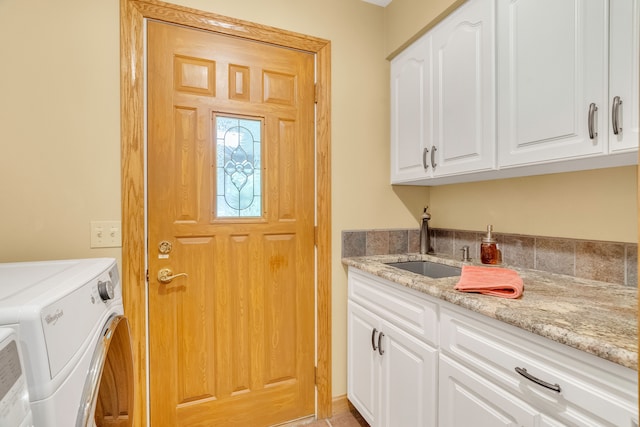 laundry area with cabinets, separate washer and dryer, and sink