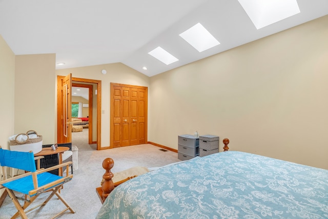 carpeted bedroom featuring vaulted ceiling with skylight and a closet