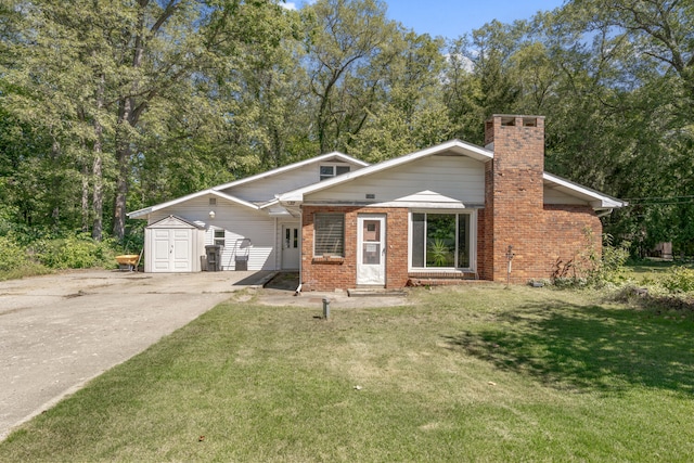 view of front of house with a front yard and a shed