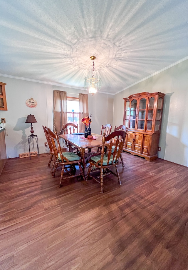 dining space featuring ornamental molding, dark wood-type flooring, and an inviting chandelier