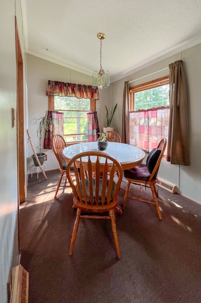 dining room featuring a textured ceiling, carpet floors, an inviting chandelier, and crown molding