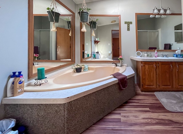 bathroom featuring wood-type flooring, vanity, and separate shower and tub