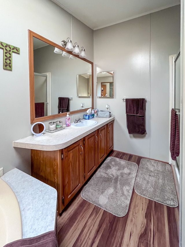 bathroom with vanity, hardwood / wood-style flooring, and a shower with shower door