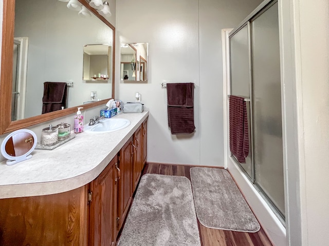 bathroom featuring hardwood / wood-style floors, vanity, and an enclosed shower