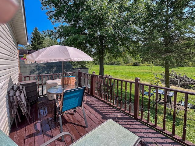 wooden deck featuring a lawn