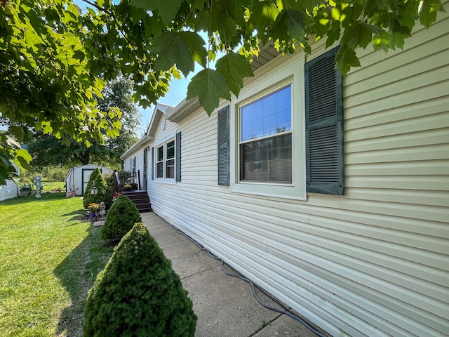 view of home's exterior featuring a lawn and a storage shed