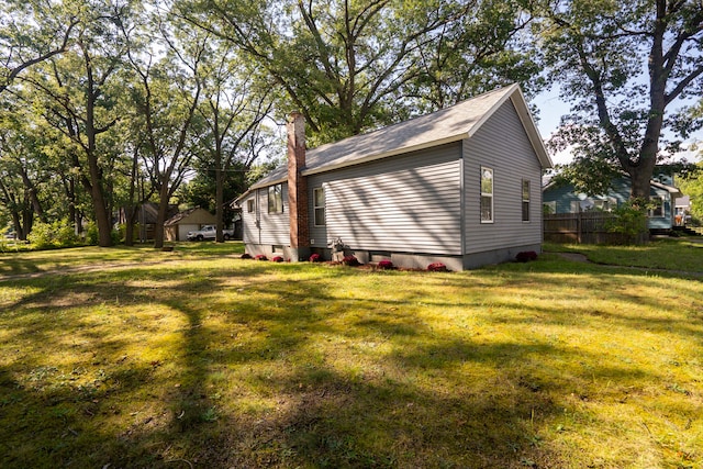 view of side of home featuring a yard and a chimney