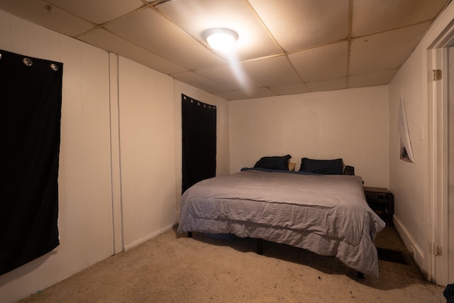 bedroom featuring a drop ceiling and carpet