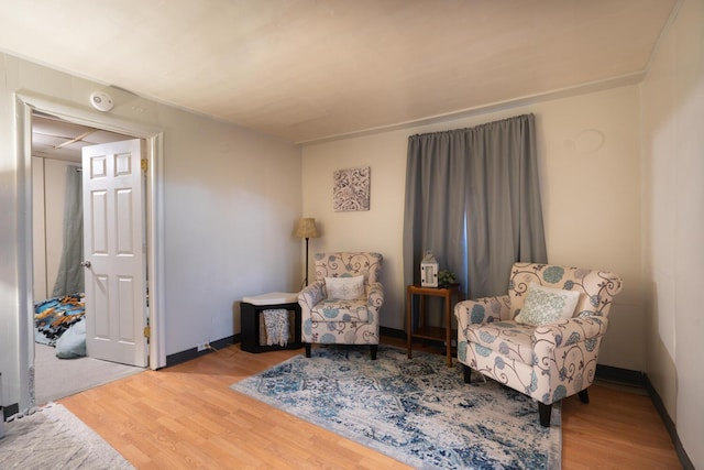 living area with baseboards and wood finished floors