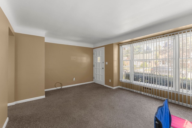 unfurnished room with dark carpet