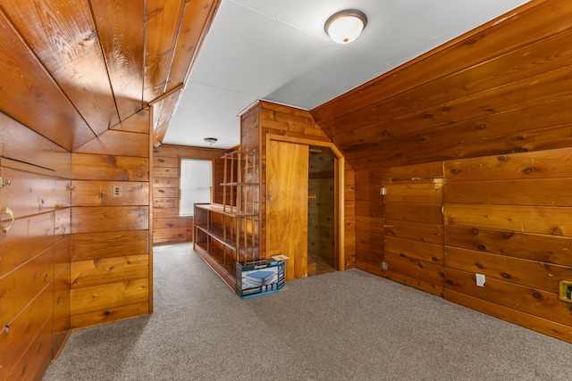 additional living space with lofted ceiling, carpet floors, and wooden walls