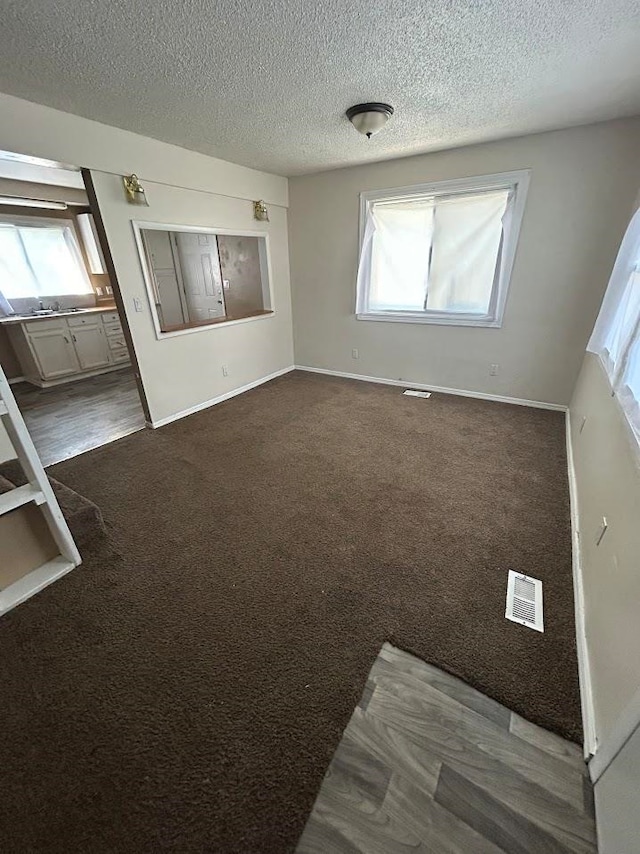 carpeted spare room featuring a textured ceiling