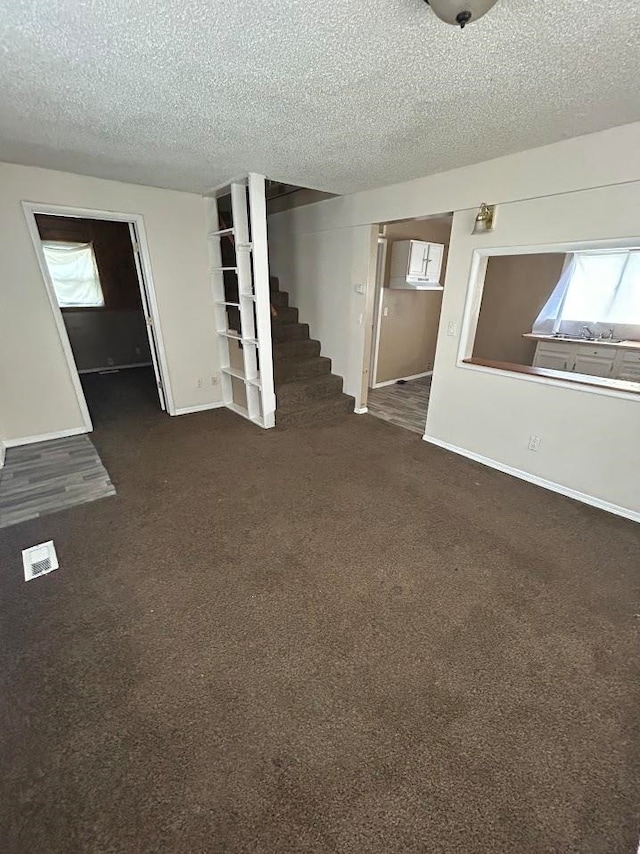 carpeted empty room with a textured ceiling