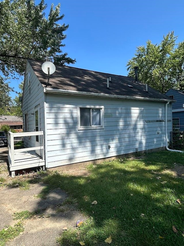 view of side of home featuring a yard and a wooden deck