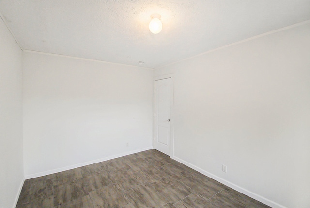 empty room with a textured ceiling and dark wood-type flooring