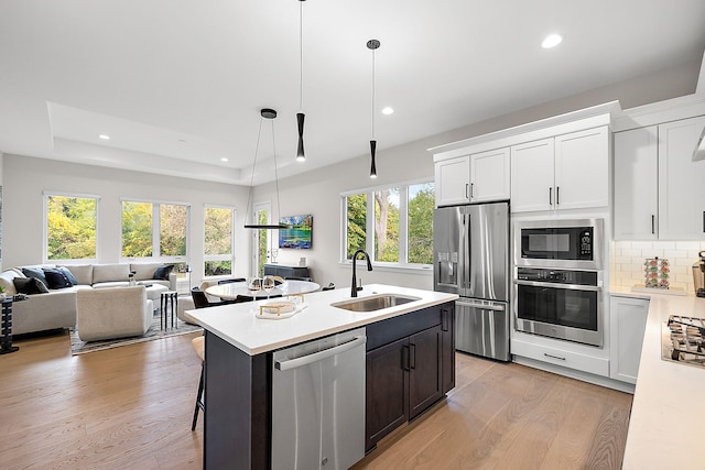 kitchen with sink, white cabinetry, stainless steel appliances, and a wealth of natural light