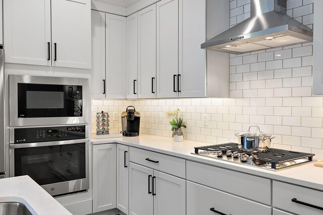 7464 Gramercy Cir Unit 19, West Bloomfield, MI 48322 - kitchen featuring wall chimney range hood, stainless steel appliances, light countertops, and tasteful backsplash