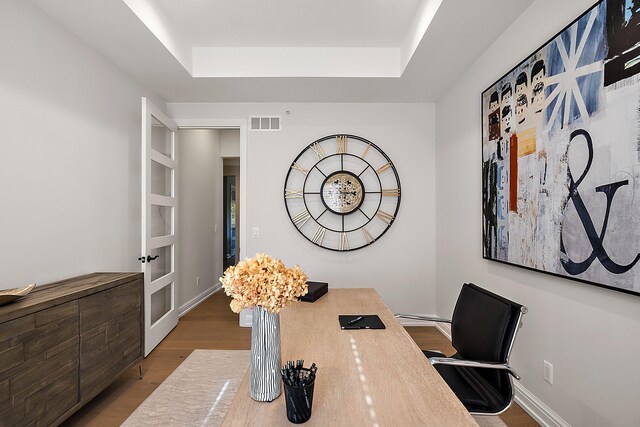 office area featuring a raised ceiling and wood-type flooring