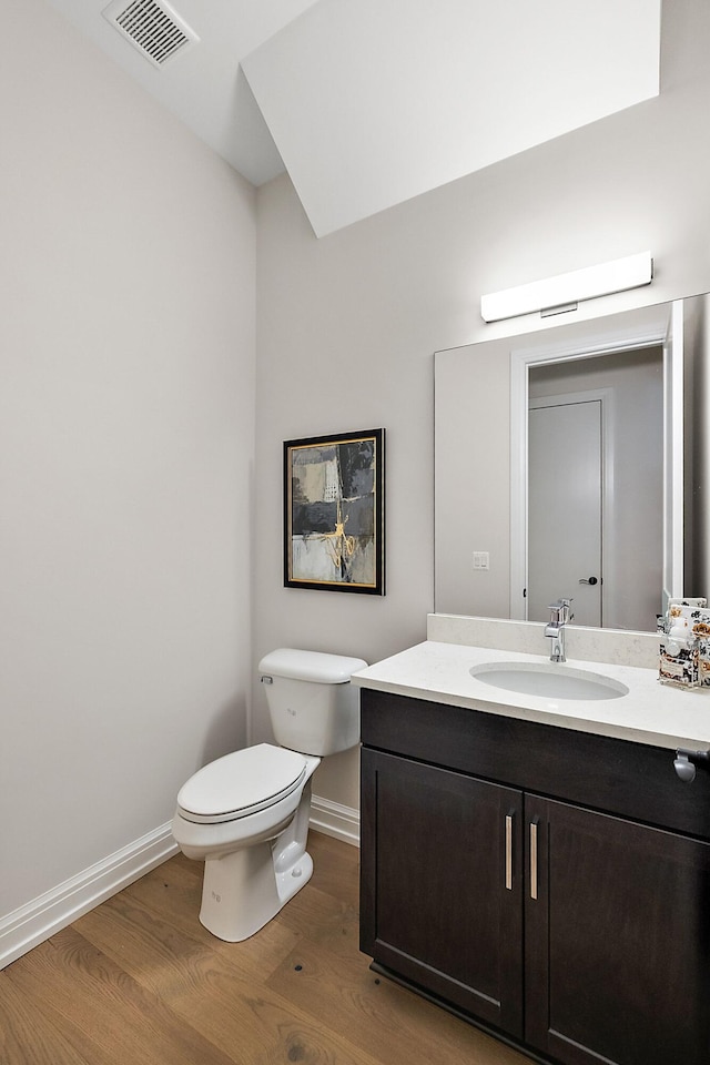 bathroom with hardwood / wood-style floors, vanity, and toilet